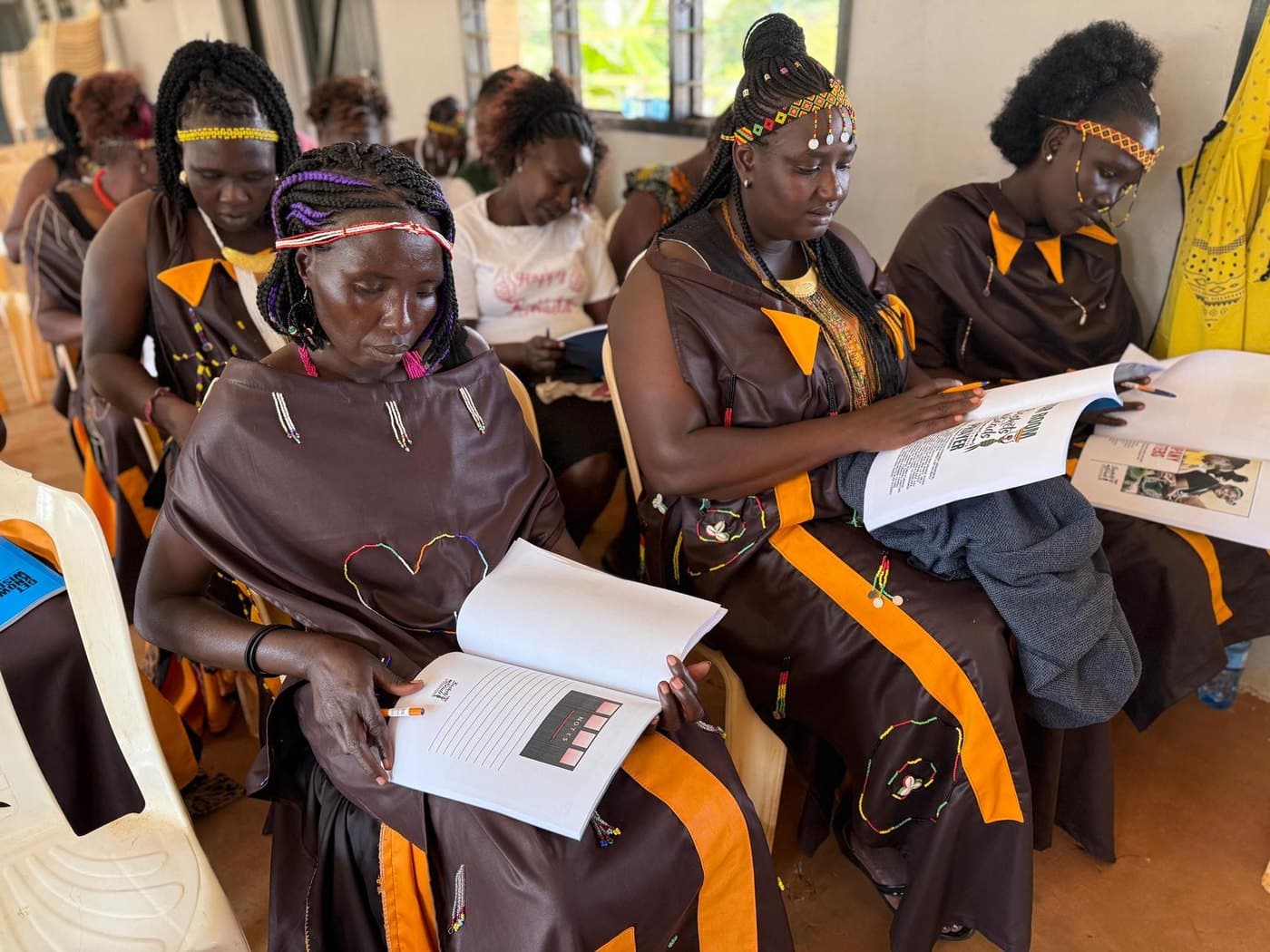 Women reading and writing together in the literacy class