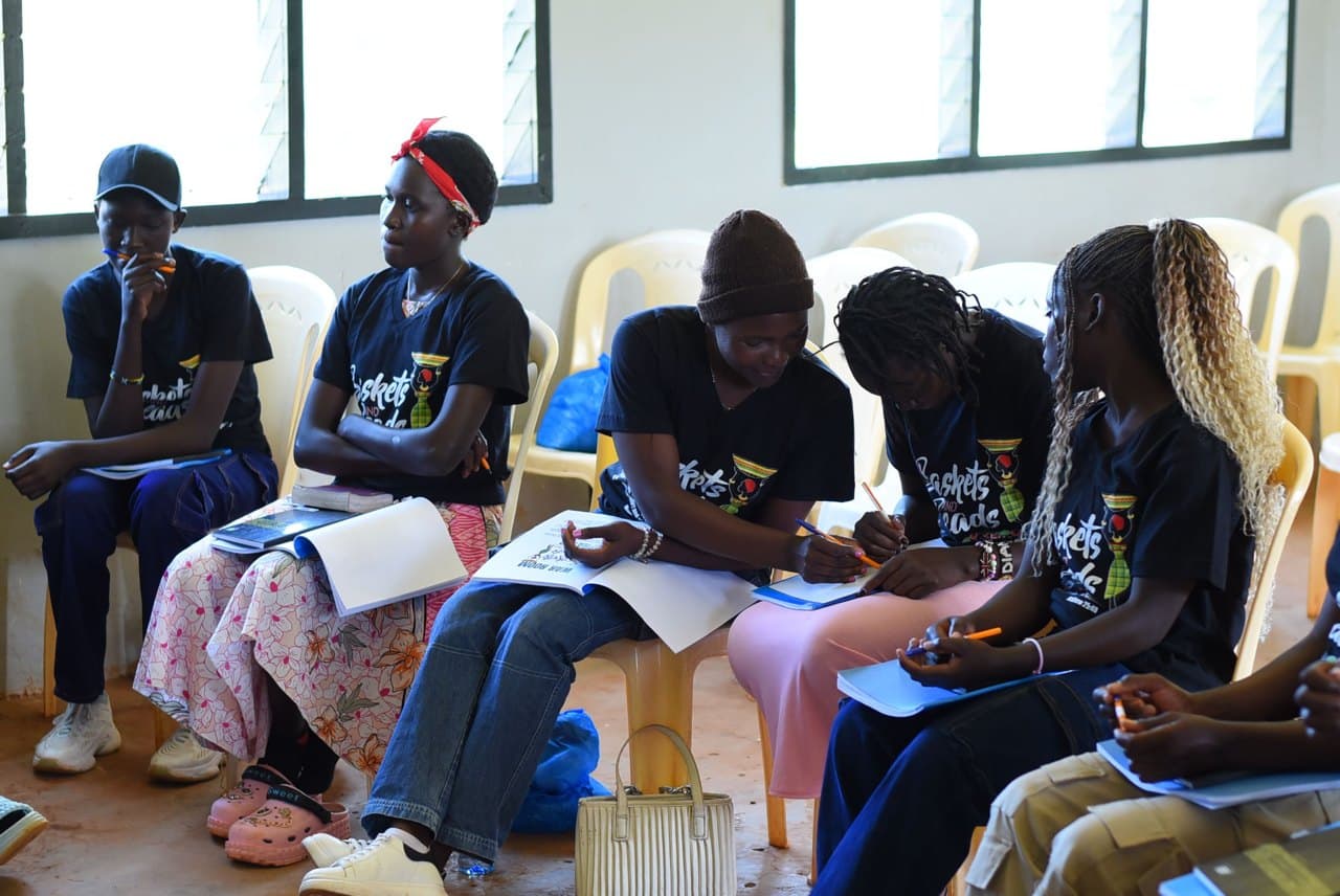 Students seated in class, writing in their notebooks
